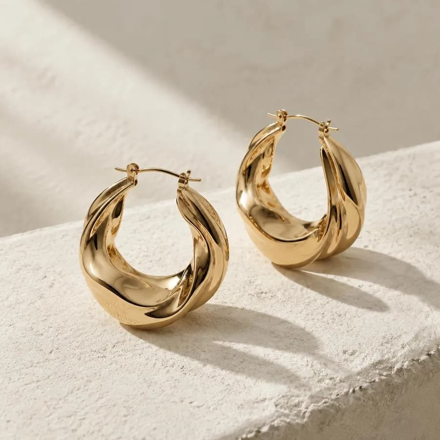 Gold hoop earrings in a warm product photograph