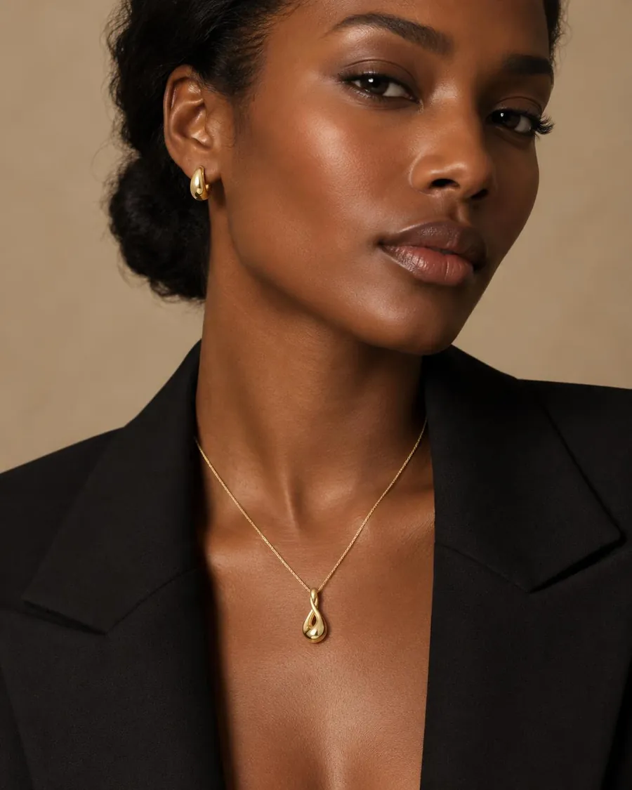 Gold pendant necklace worn with black tailoring